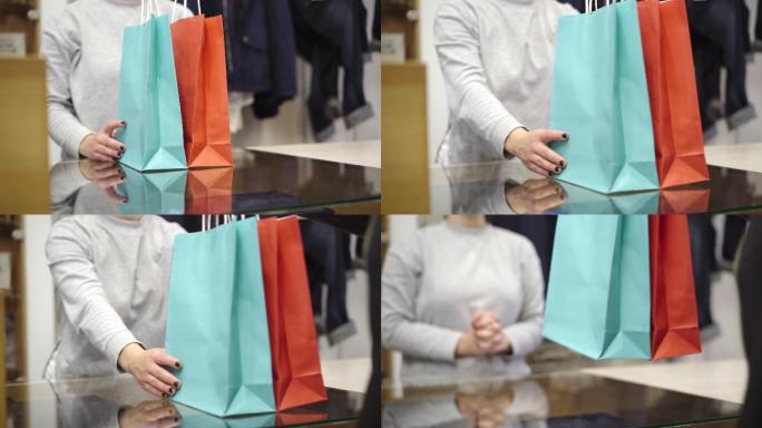 一位女子在商店的收银台把购物袋递给顾客。