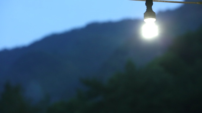 农村门口群山背景一盏灯点亮蓝色安静温馨