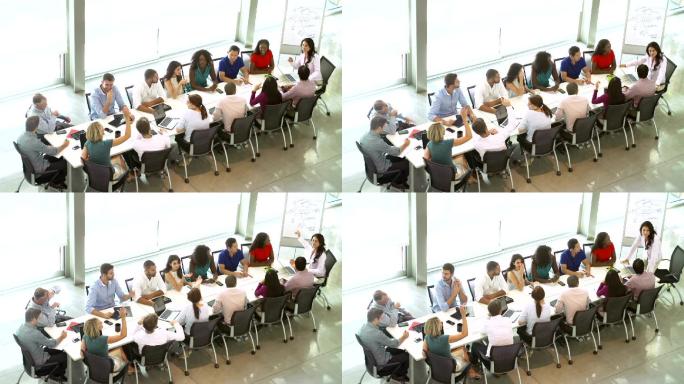 女商人向坐在董事会会议桌旁的同事们做演讲