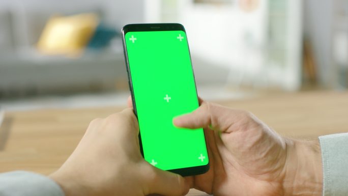 一名男子使用绿色屏幕手机的特写镜头