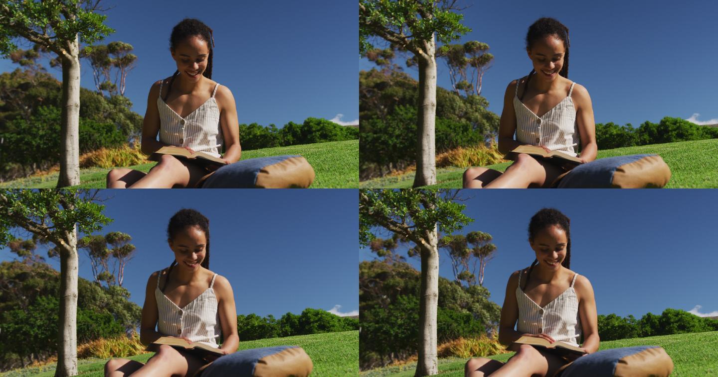 一名妇女坐在公园的草地上看书