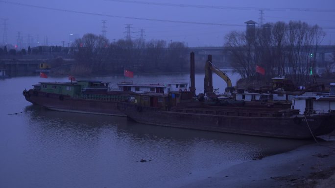 傍晚河边停靠的破旧鱼船