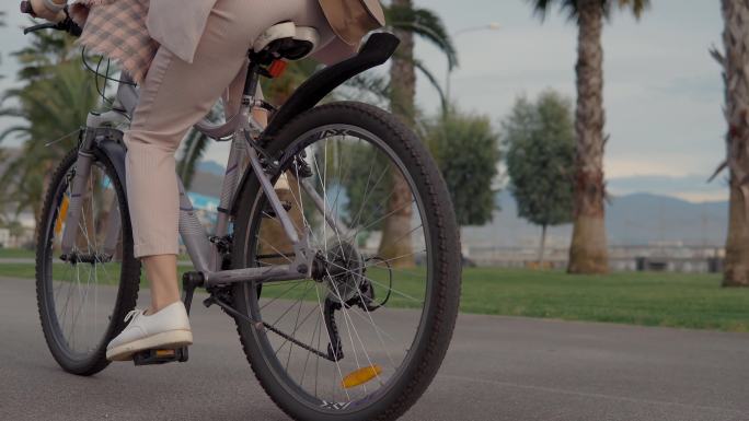 女人正在公园里踩自行车的踏板