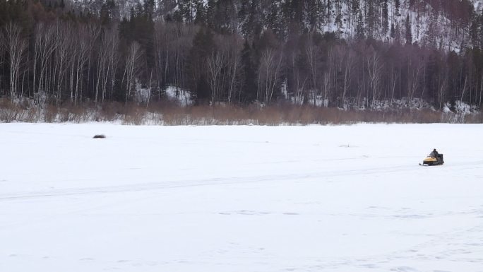 在冰冻的河面上骑着摩托雪橇