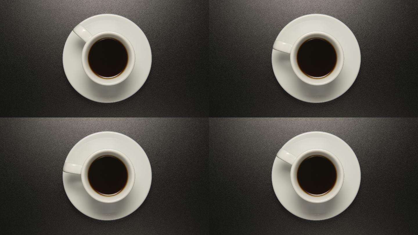 咖啡杯在黑色桌子上旋转