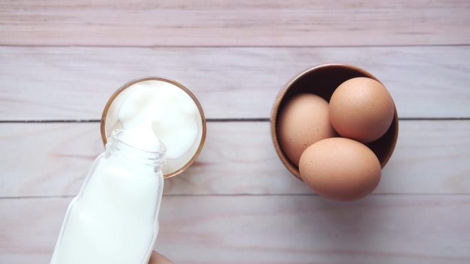 桌上一杯牛奶和鸡蛋的俯视图