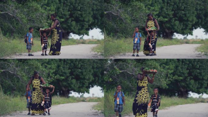 非洲女人头顶蔬菜篮子接孩子放学回家