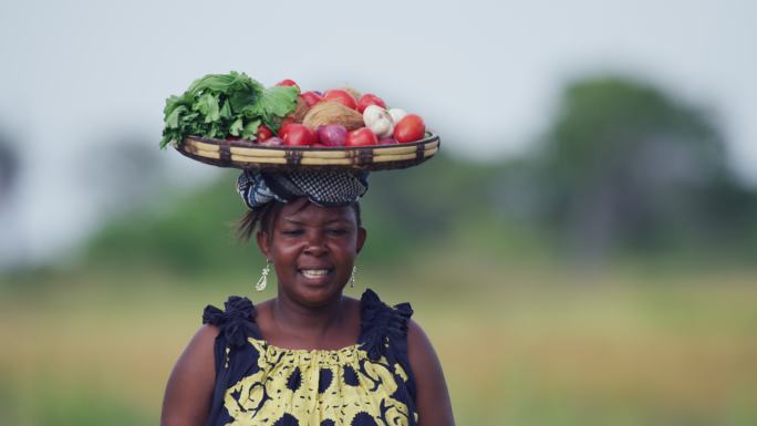非洲女人头顶蔬菜篮子接孩子放学回家