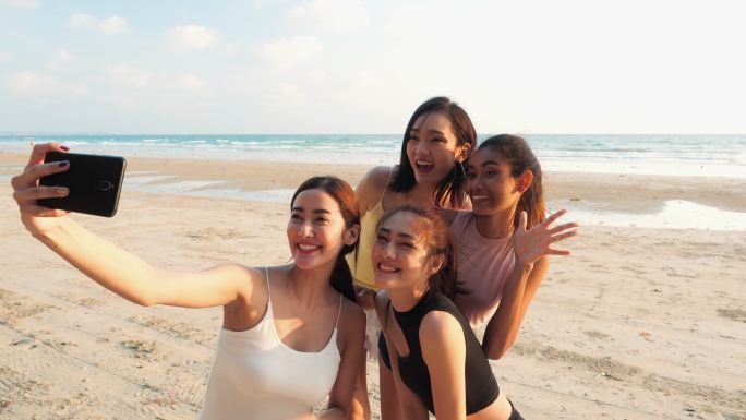 四个年轻女孩在海滩自拍