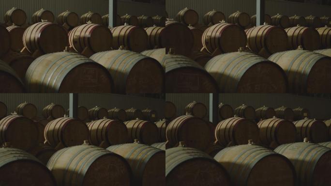 在一个大仓库里放着陈年木桶和葡萄酒