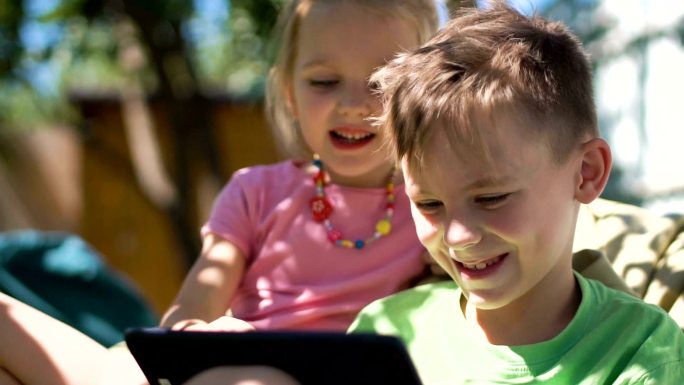 孩子们在后院玩平板电脑