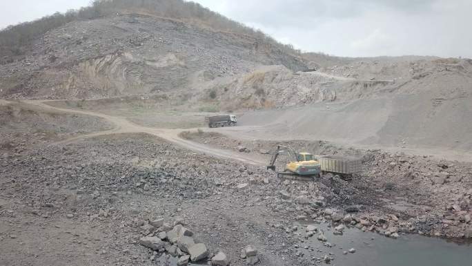 挖掘机将岩石装载到自卸卡车中。