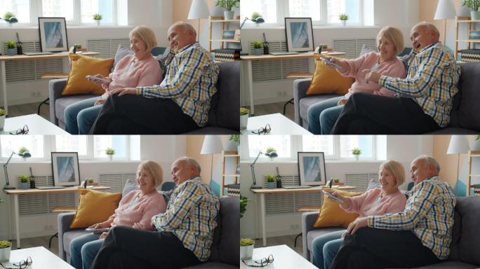 老年男女在公寓的沙发上看电视和聊天