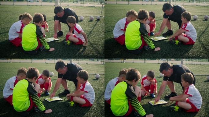 教练正在向小男孩展示足球场的平面图