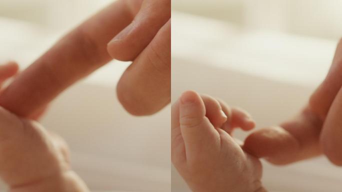 新生儿手握住母亲的手指