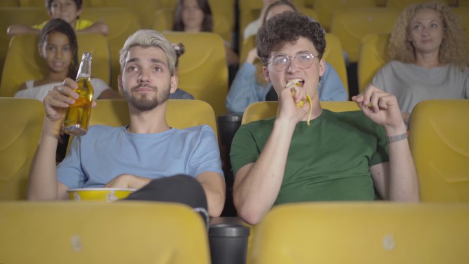 在电影院里喝啤酒吃香蕉的男人