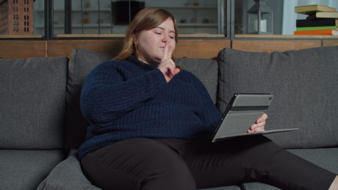 聋哑妇女在平板电脑上使用手语交谈