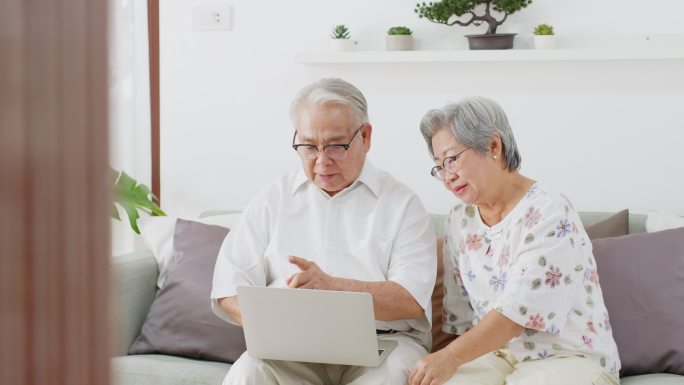 老年夫妇使用笔记本电脑进行互联网搜索