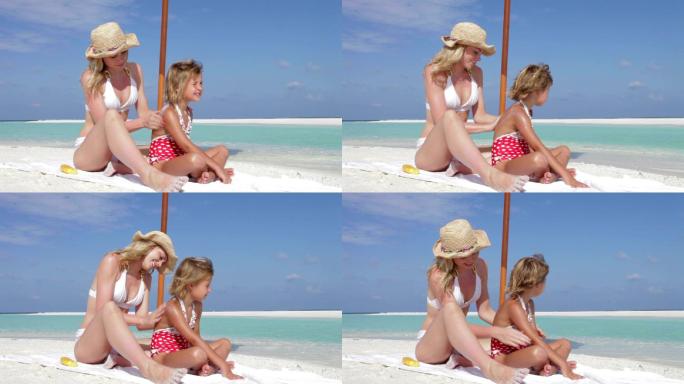 海滩度假母亲为女儿涂防晒霜