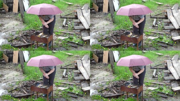 雨天，女人拿着雨伞在烤肉架上生火