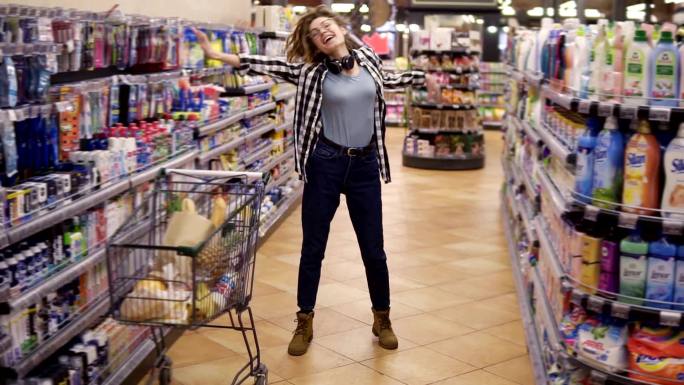 年轻女子站在杂货店过道上跳舞