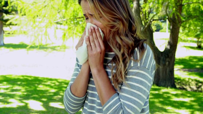 妇女用纸巾擤鼻涕感冒废纸垃圾桶