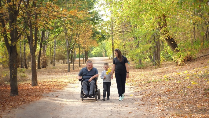 一位坐着自动轮椅的年轻残疾人和他的家人