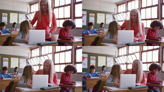 一个女孩坐在课桌上用笔记本电脑，老师帮她