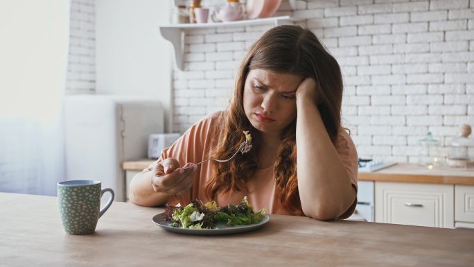 女人对吃沙拉的饮食感到不满