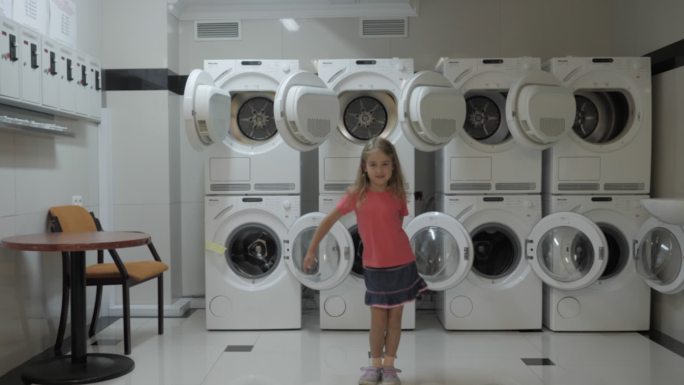 快乐的小女孩在洗衣房跳舞