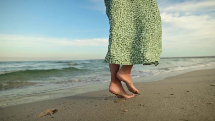 海滩上的年轻女子行走光脚丫赤脚脚步吹海风