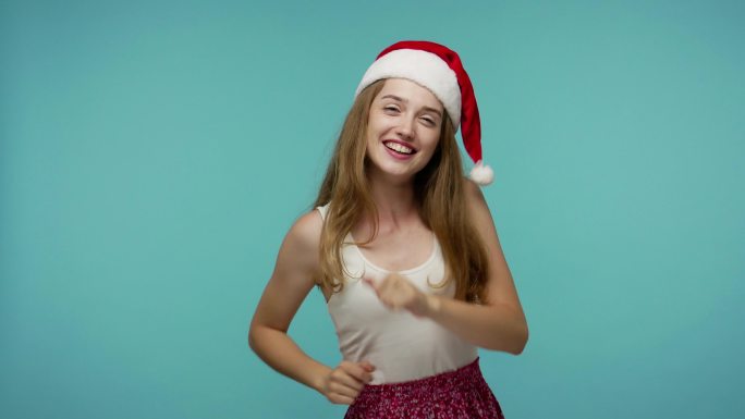 可爱的女孩戴着滑稽的圣诞老人帽