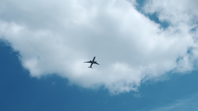 一架客机在蓝天上飞过云层