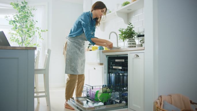女性正在把脏盘子装进洗碗机