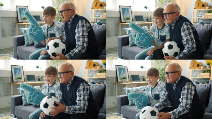 爷爷和快乐的男孩在电视上看足球