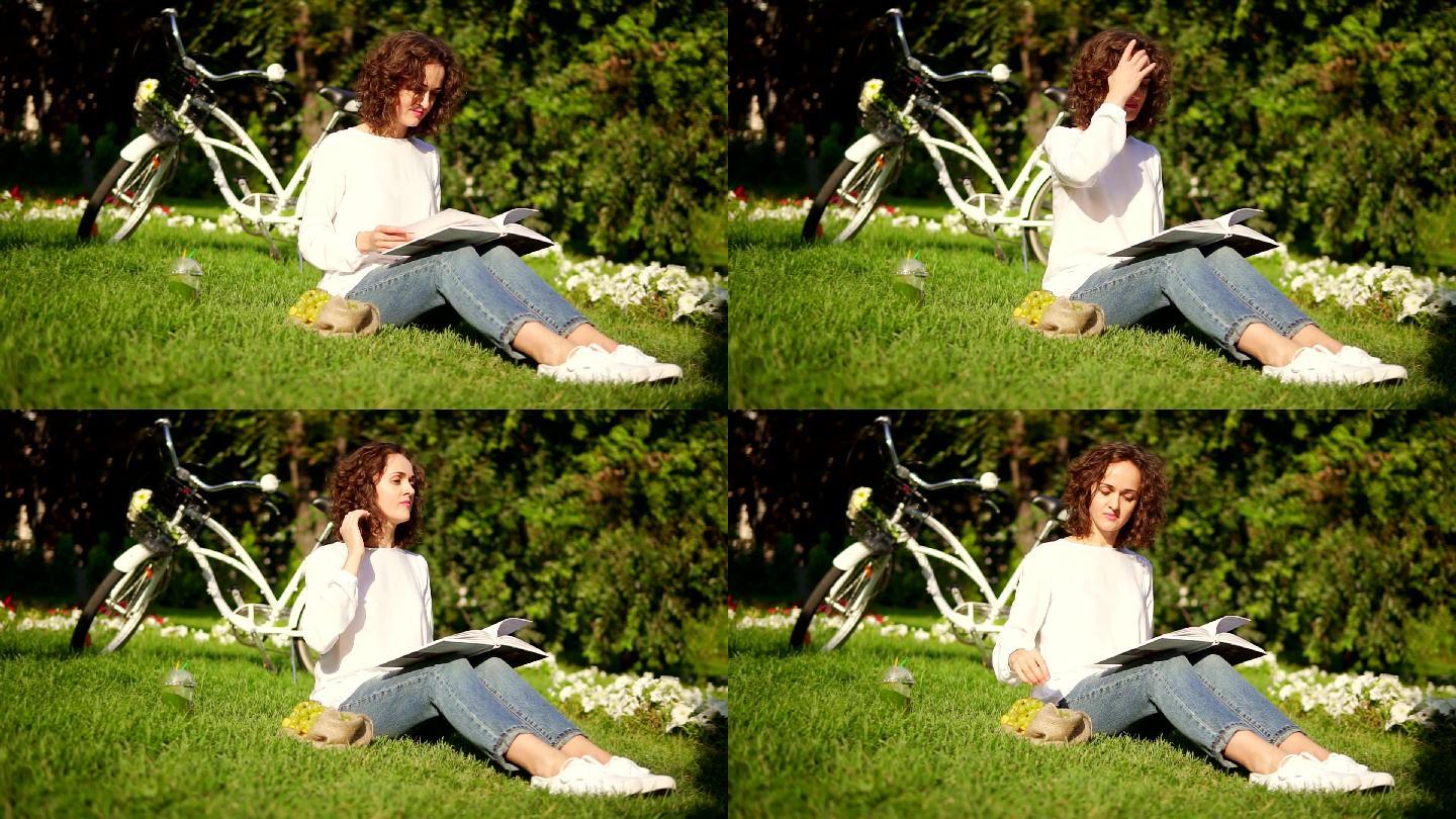女子正坐在公园的草地上看书