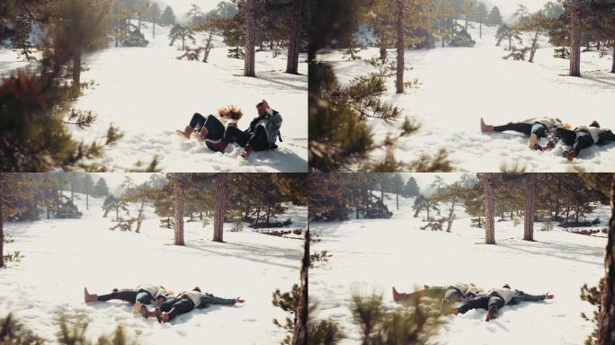一对年轻夫妇躺在雪地里做雪天使