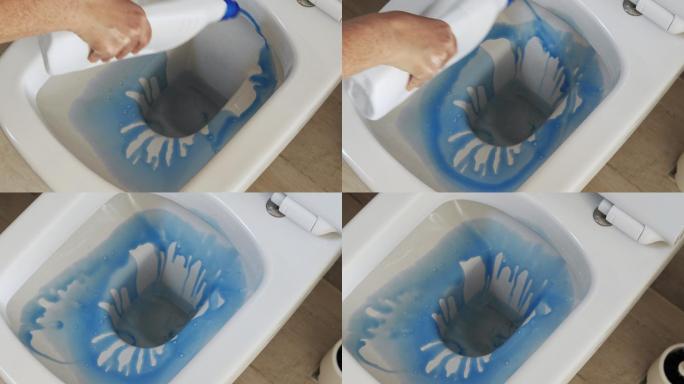 用蓝色清洁液清洁浴室中的白色马桶