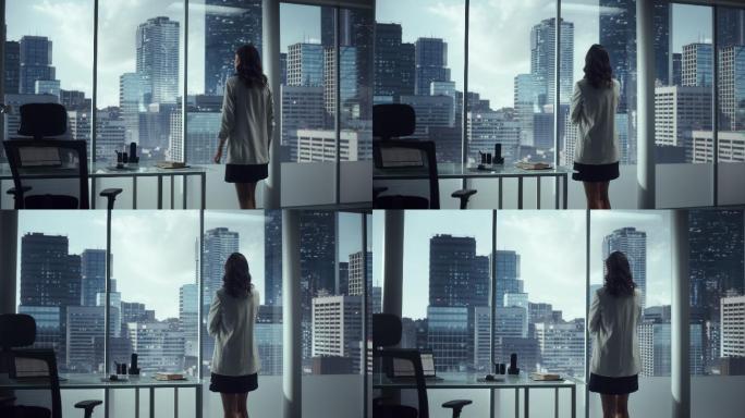 女商人站在办公室向窗外眺望大城市