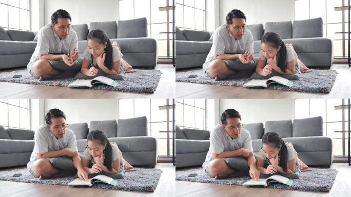 父亲在客厅的地板上教女儿读书。