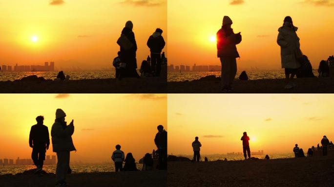 落日剪影，年轻人海边看夕阳