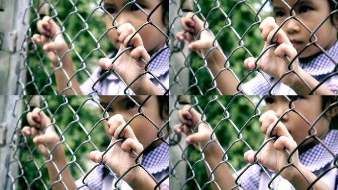 一个小女孩摇动铁栅栏的特写镜头