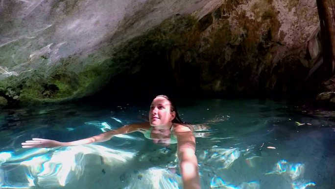 女子在洞穴内的淡水中游泳