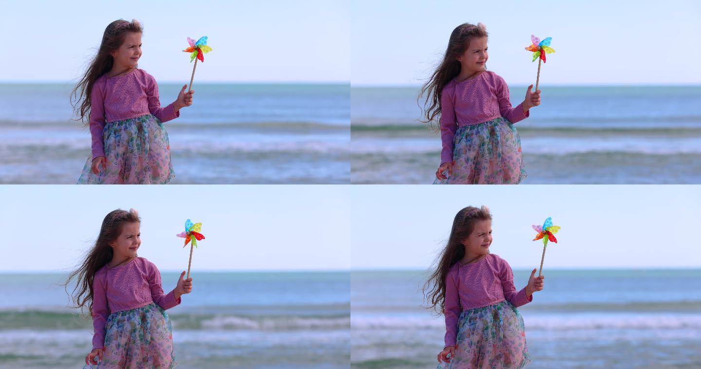 女孩在海滩上玩旋转的彩色风车