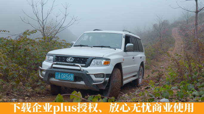 冬季山乡冰雪泥泞山路上艰难行驶的越野车