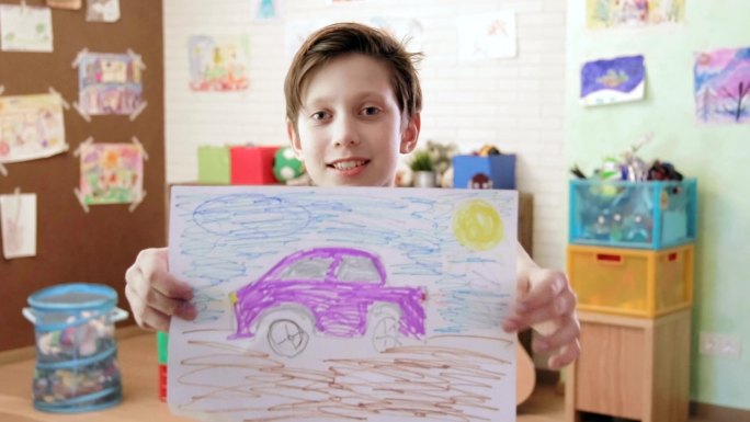 可爱的微笑男孩展示了汽车画