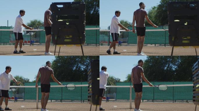 网球教练在球场上与男子一起练习