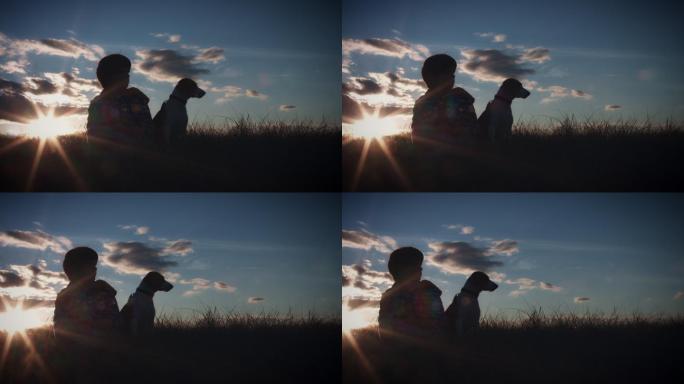 儿童和狗观看日落的剪影