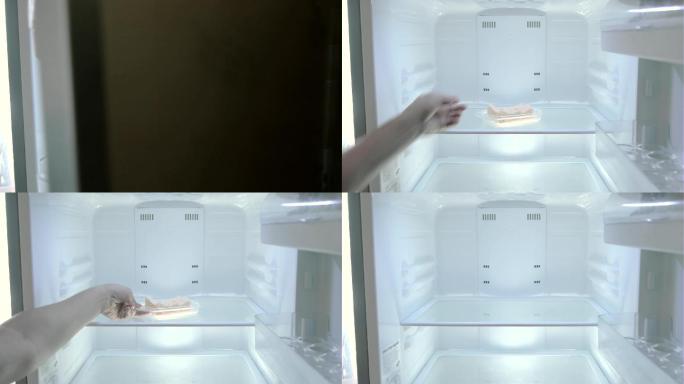 男人从空冰箱里拿出黄油