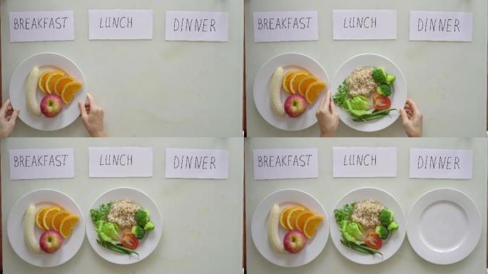 妇女把一个盘子分别放在早餐和午餐的标题下